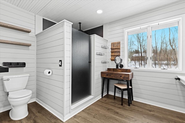 bathroom with toilet, hardwood / wood-style floors, and wood walls