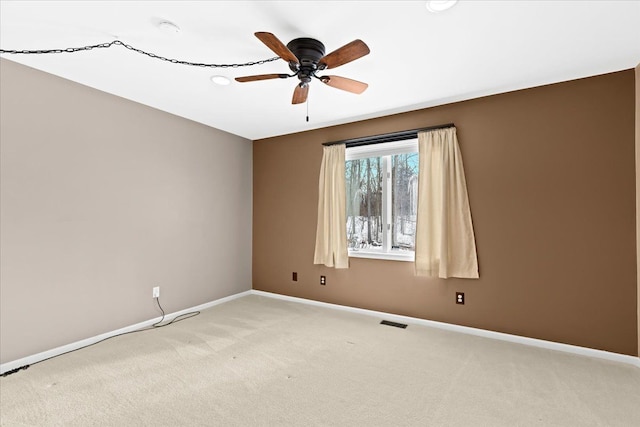 carpeted spare room with ceiling fan