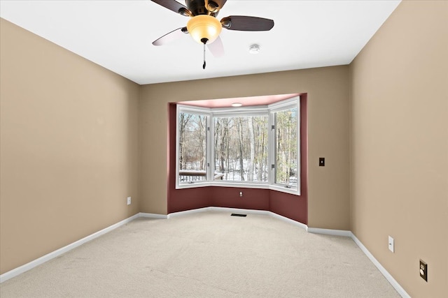 spare room with light colored carpet and ceiling fan