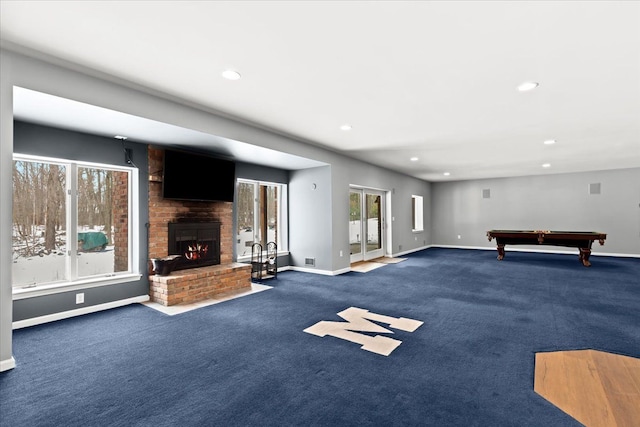 playroom with a brick fireplace, dark carpet, and pool table