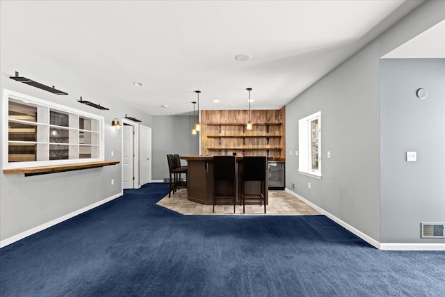 bar featuring decorative light fixtures, a barn door, and dark colored carpet