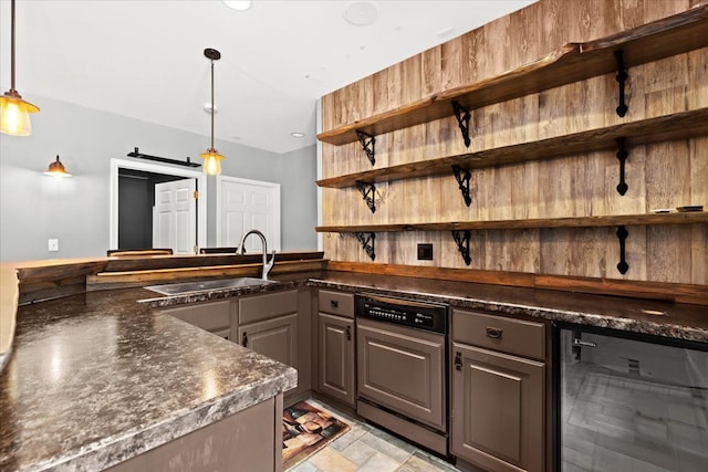 kitchen featuring wine cooler, sink, decorative light fixtures, a barn door, and paneled dishwasher