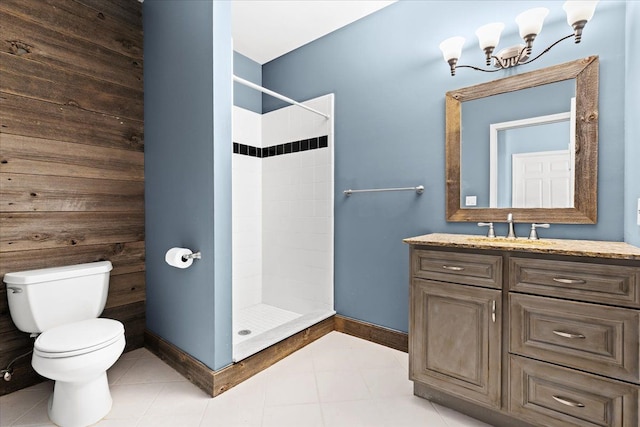 bathroom with a tile shower, vanity, a chandelier, and toilet