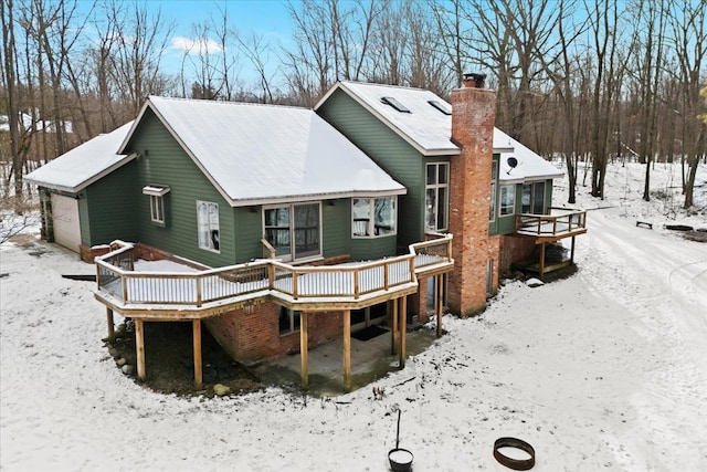 snow covered property with a deck