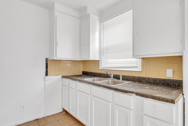 kitchen with white cabinetry, sink, light tile patterned floors, and tasteful backsplash