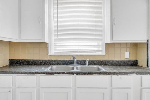 kitchen featuring sink, decorative backsplash, and white cabinets