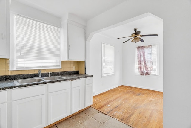 kitchen with sink, white cabinets, backsplash, and light hardwood / wood-style flooring