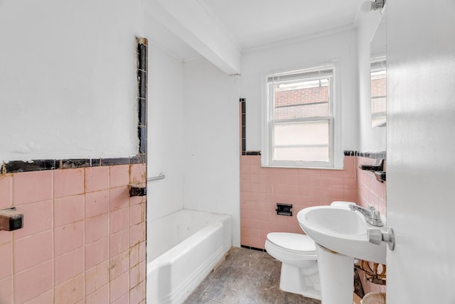 bathroom featuring toilet, tile walls, and a tub