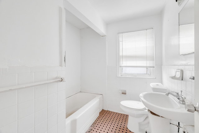 bathroom featuring tile walls, sink, a bathtub, and toilet