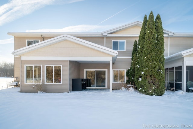 view of snow covered back of property