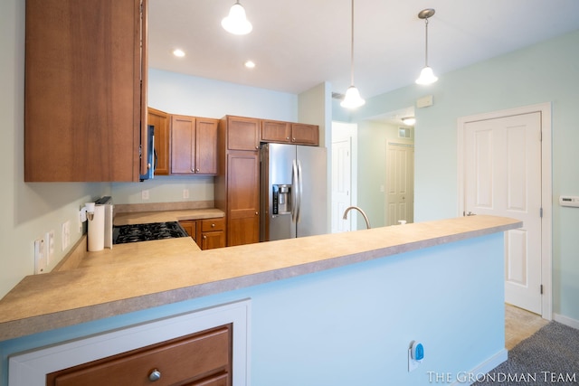 kitchen featuring appliances with stainless steel finishes, sink, kitchen peninsula, and decorative light fixtures