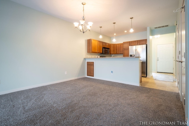 kitchen with light colored carpet, appliances with stainless steel finishes, decorative light fixtures, and kitchen peninsula