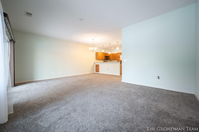 unfurnished living room with an inviting chandelier and light colored carpet