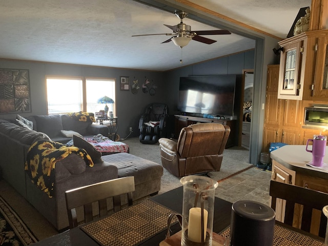 carpeted living room with ceiling fan, vaulted ceiling, and a textured ceiling