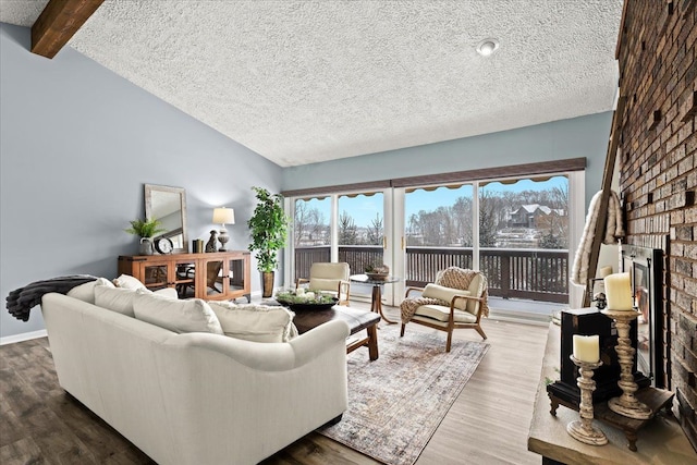 living room featuring a brick fireplace, a textured ceiling, and a wealth of natural light