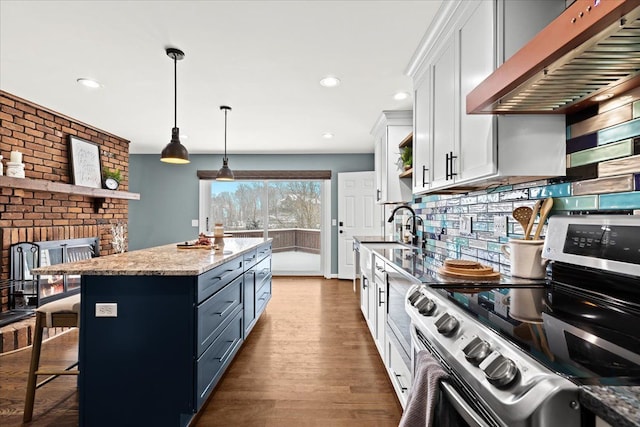 kitchen with pendant lighting, a kitchen island, stainless steel range with electric cooktop, white cabinets, and wall chimney exhaust hood