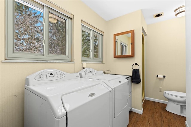 washroom with dark hardwood / wood-style flooring and washing machine and dryer