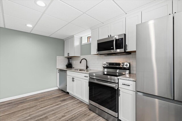 kitchen featuring white cabinetry, sink, a drop ceiling, and appliances with stainless steel finishes