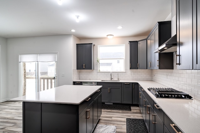 kitchen with a kitchen island, stainless steel gas cooktop, plenty of natural light, and sink