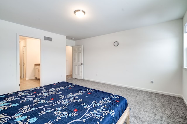 bedroom featuring ensuite bathroom and carpet floors