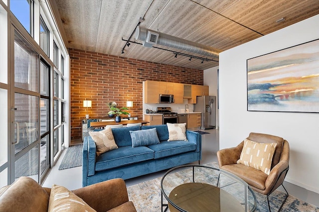 living room featuring sink, brick wall, and track lighting