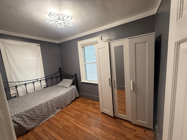 bedroom featuring hardwood / wood-style flooring and crown molding