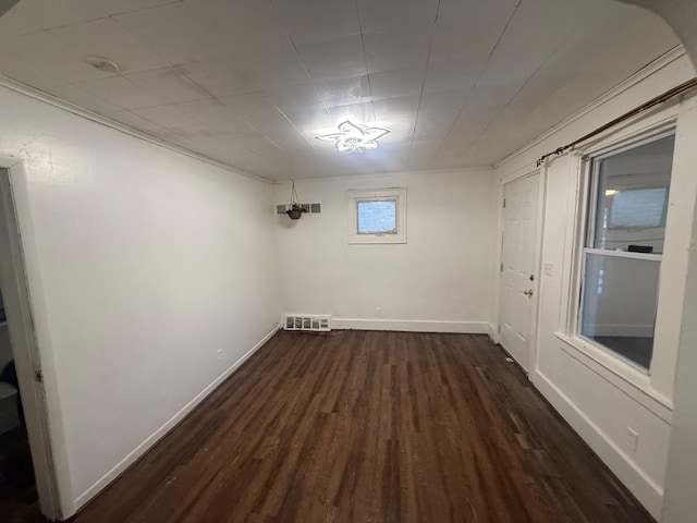 basement featuring dark hardwood / wood-style flooring and crown molding