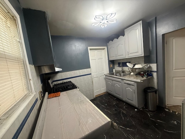 kitchen featuring white cabinets, sink, and stainless steel range with gas cooktop