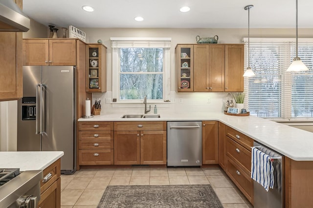 kitchen with extractor fan, pendant lighting, sink, stainless steel appliances, and light tile patterned floors