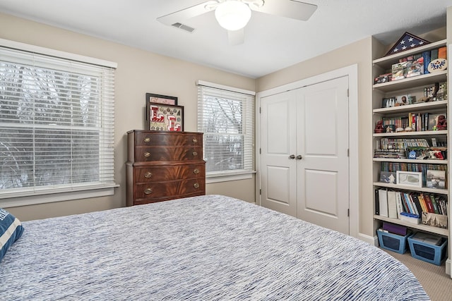 bedroom featuring ceiling fan, a closet, and light carpet