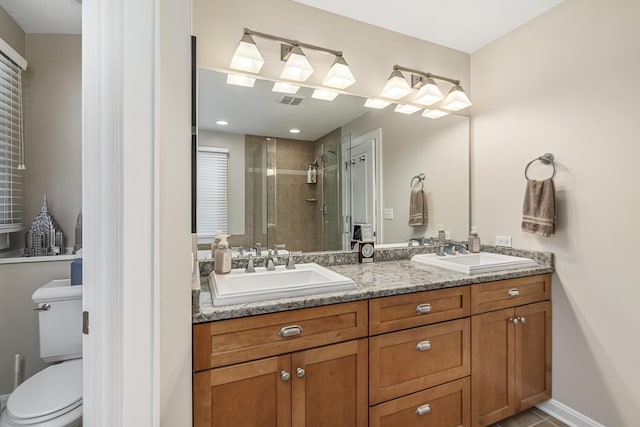 bathroom with a shower with shower door, toilet, vanity, and tile patterned flooring