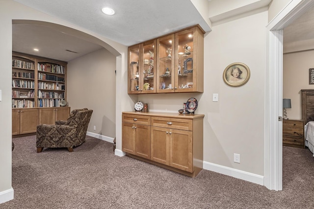 sitting room featuring dark carpet and a textured ceiling