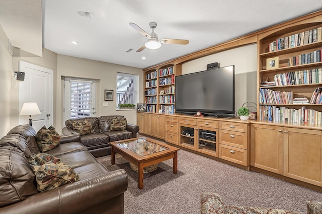 living room featuring ceiling fan, carpet, and built in shelves