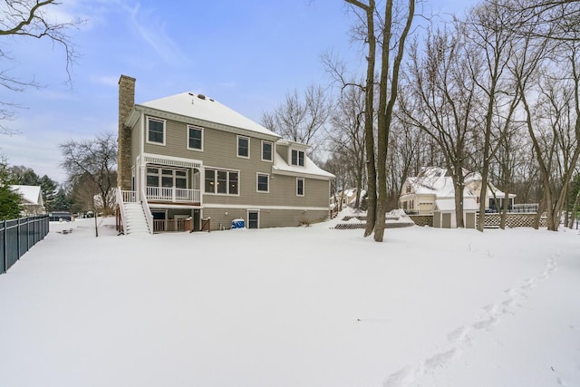 view of snow covered back of property