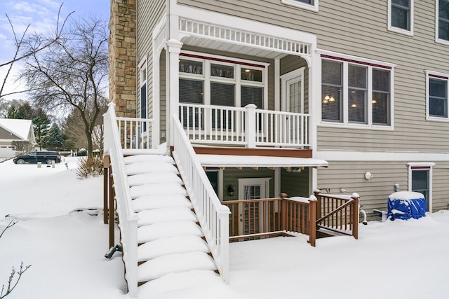 view of snow covered back of property