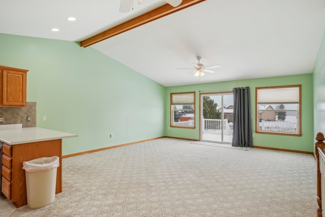 unfurnished living room featuring ceiling fan, lofted ceiling with beams, and light carpet