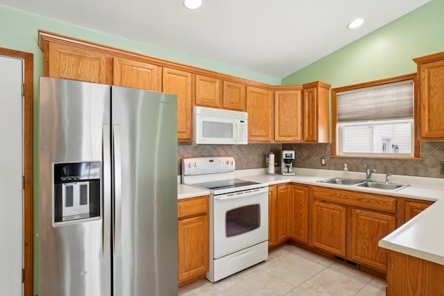 kitchen featuring light tile patterned flooring, lofted ceiling, sink, tasteful backsplash, and white appliances