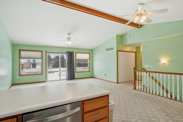 kitchen with lofted ceiling with beams, stainless steel dishwasher, light colored carpet, and ceiling fan