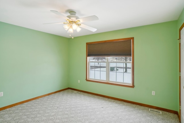 carpeted spare room with ceiling fan