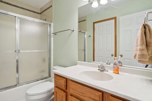 full bathroom featuring vanity, toilet, and combined bath / shower with glass door