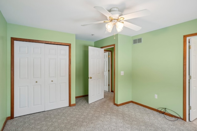 unfurnished bedroom with light colored carpet, ceiling fan, and a closet