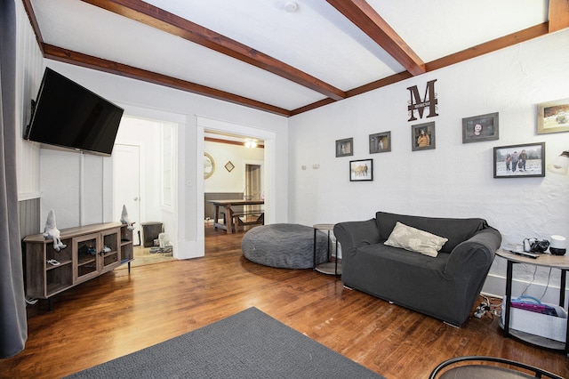 living room with dark wood-type flooring and beamed ceiling