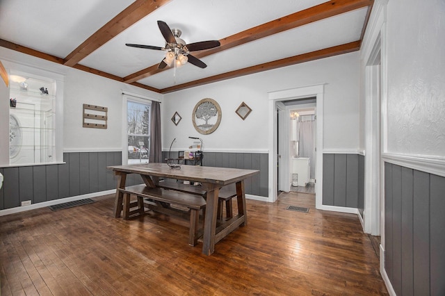 dining area with ceiling fan, dark wood-type flooring, and beam ceiling