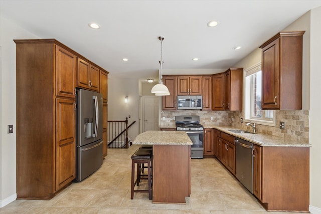 kitchen with a kitchen island, decorative light fixtures, stainless steel appliances, tasteful backsplash, and sink