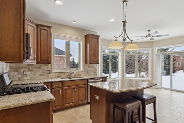 kitchen featuring light stone countertops, appliances with stainless steel finishes, tasteful backsplash, and sink