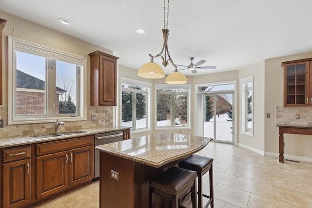 kitchen with tasteful backsplash, dishwasher, a center island, pendant lighting, and sink