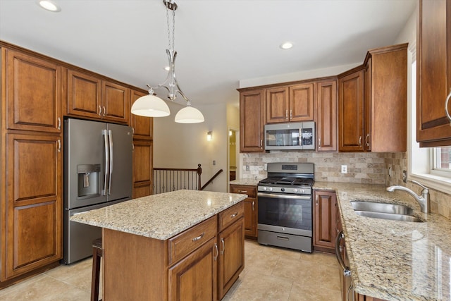 kitchen featuring light stone countertops, a center island, stainless steel appliances, sink, and hanging light fixtures