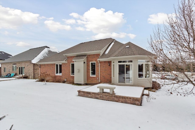 view of snow covered back of property