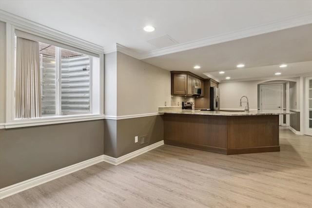 kitchen with light hardwood / wood-style floors, kitchen peninsula, crown molding, stainless steel appliances, and light stone counters