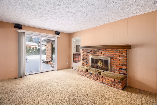 carpeted living room with a fireplace and a textured ceiling